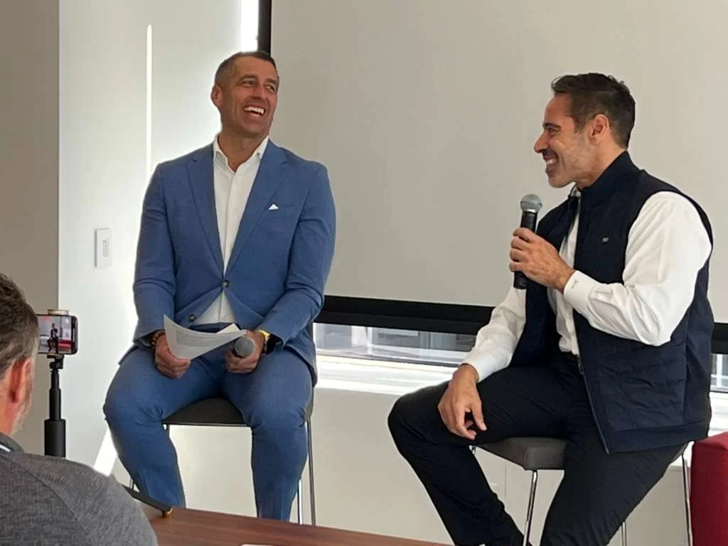 Two seated speakers with microphones at a Family Office Club fireside interview